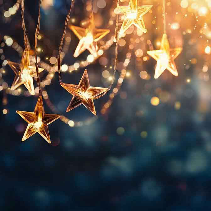slinger van gouden kerststerren met lampje erin