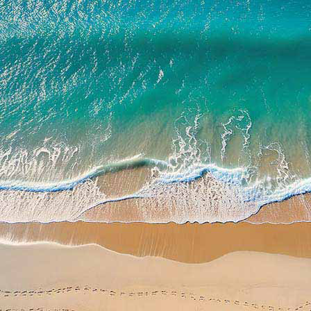 Kustlijn, voetstappen in het zand, blauwe oceaan